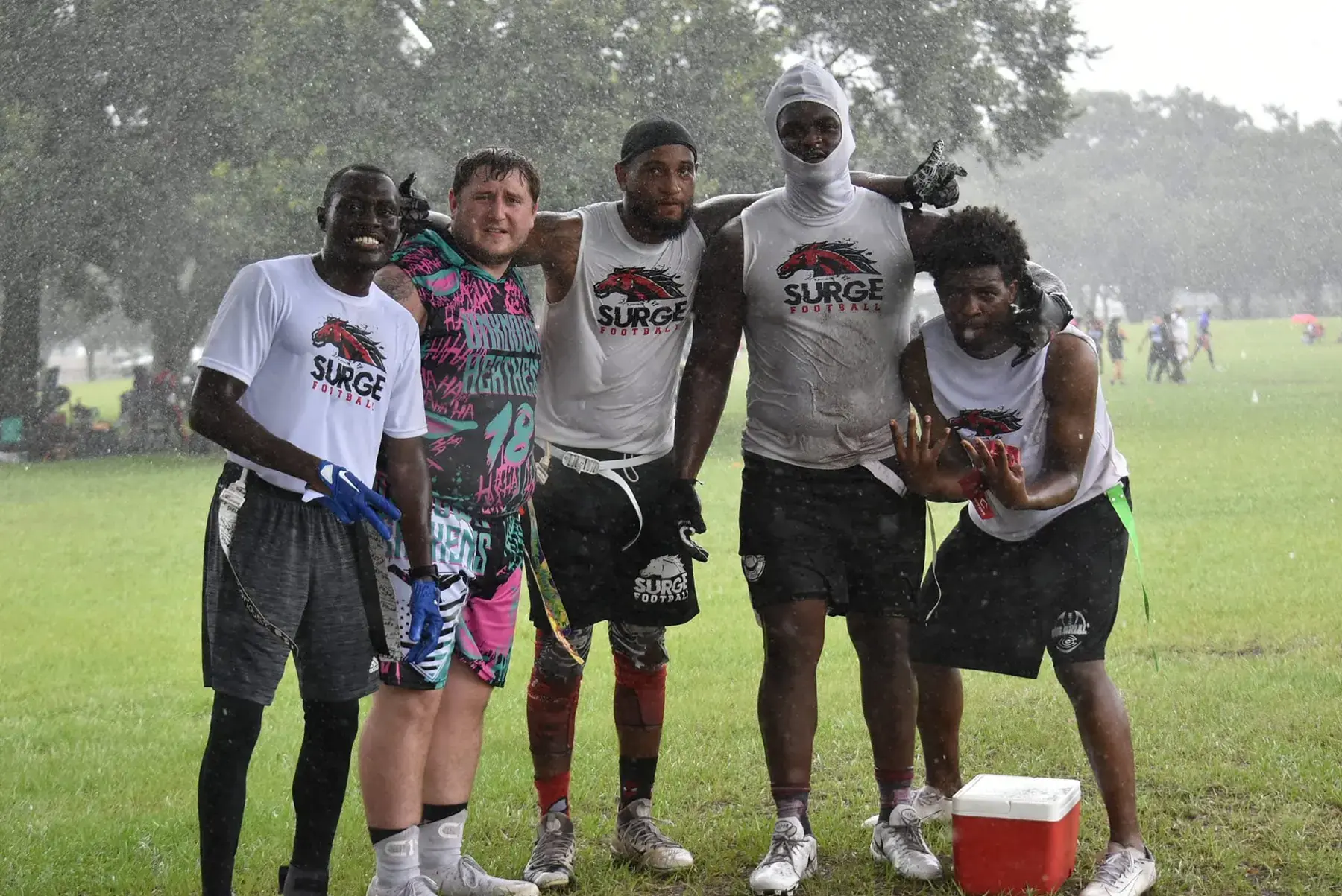 Team wearing custom COQUI shirts in the rain